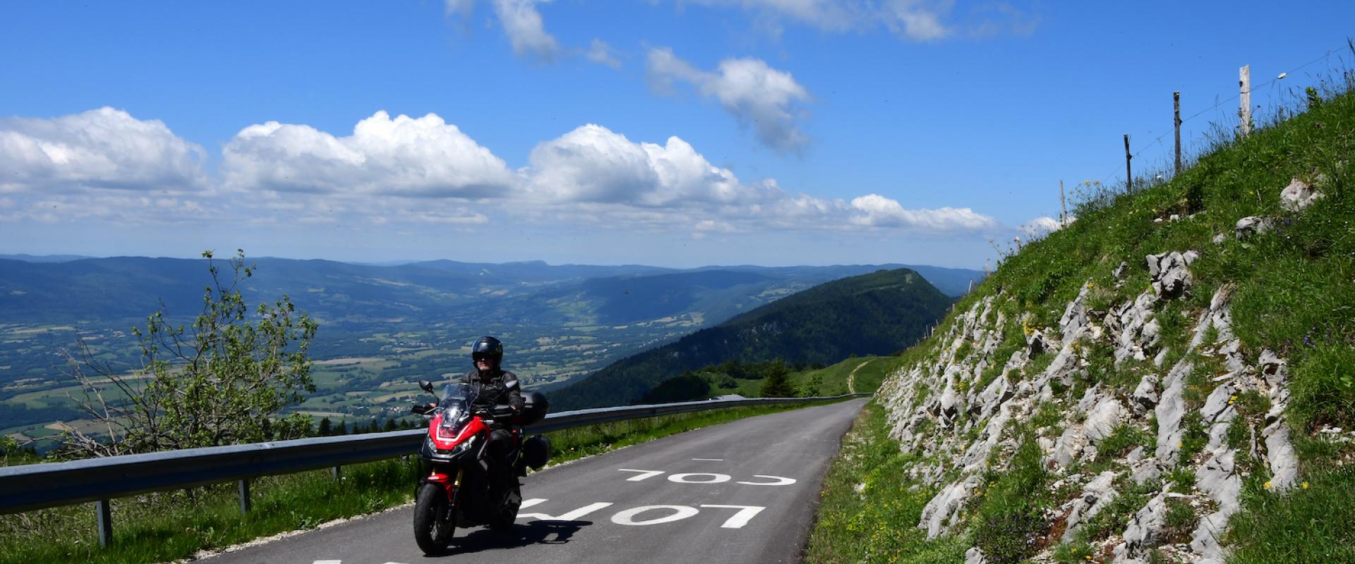 Motorradfahrer unterwegs auf Slowenische Grenzkammstraße, mit schönem Panorama