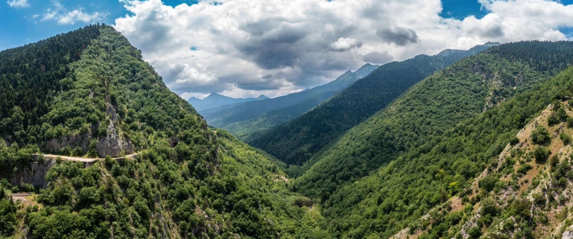 Ein Tal im Agrafa Gebirge, links und grüne rechts Berge mit Bäumen, bewölkter Himmel