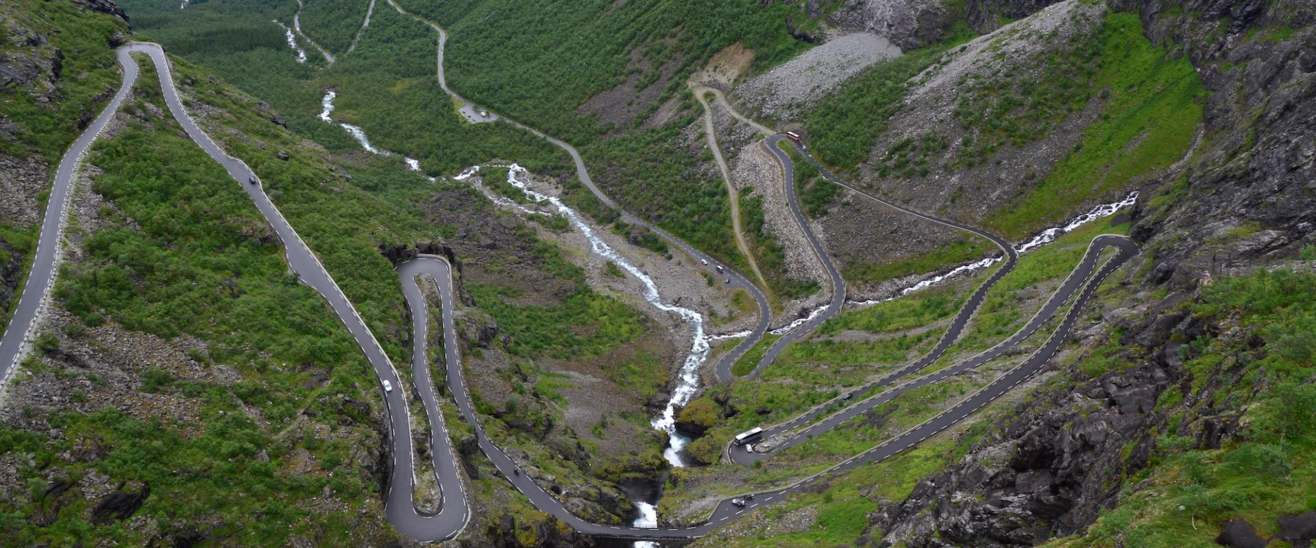 Serpentinen des Trollstigen mit Wasserfällen in grüner Berglandschaft