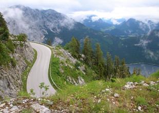 Kehre der Loser Panoramastraße, mit Blick auf einen See und umliegende Berge