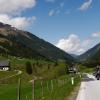 Motorradfahrer auf dem Sölkpass, mit Bergen und Wiesen im Hintergrund